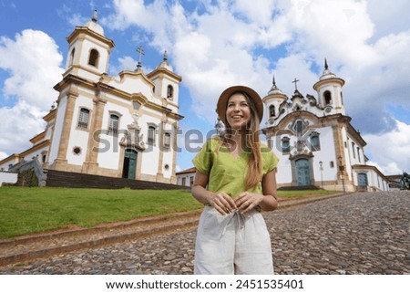 Tourism in Minas Gerais, Brazil. Young tourist woman visiting the historical town of Mariana with baroque colonial architecture. Mariana is the oldest city in the state of Minas Gerais, Brazil. Royalty-Free Stock Photo #2451535401