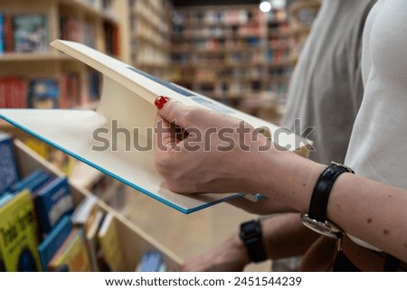A girl with a book in her hand is discussing books in the bookstore