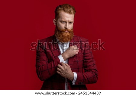Elegance of bearded gentleman in formal suit. Formalwear. Tux man in formalwear isolated on red. Redhead man in formalwear tuxedo. Man wear elegant formal menswear. Black-tie tuxedo Royalty-Free Stock Photo #2451544439