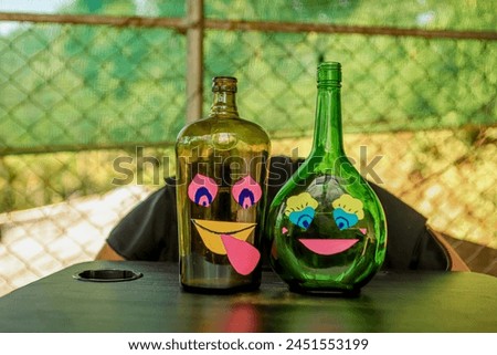 Conceptual Brown and green love wine bottles love each other. hand crafted smile cartoon on the bottle