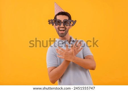 Funny young man wearing party glasses with party hat