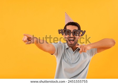 Funny young man wearing party glasses with party hat