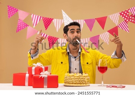 Happy young man blowing party horn on his birthday