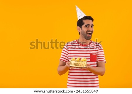 Portrait of happy young man with birthday cake in hand