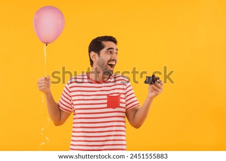 Portrait of happy young man holding balloon and a piece of cake in hands