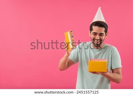 Excited young man wearing party hat and opening surprise gift box
