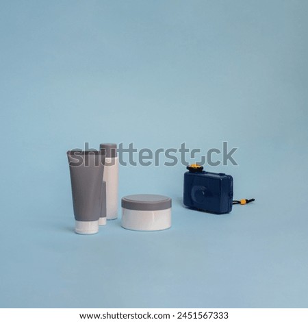 Creative summer objects concept. Toy camera and cosmetics products on a blue background. 