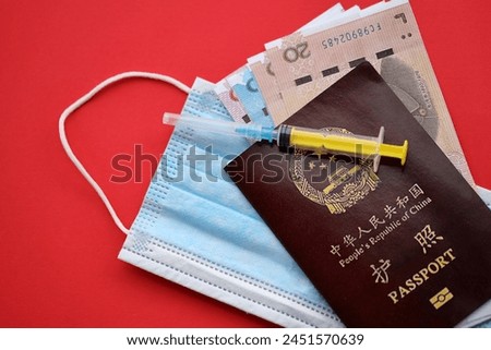Red passport of People Republic of China and chinese yuan money bills with syringe and mask. PRC chinese passport on bright background close up