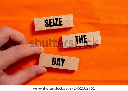 Seize the day words written on wooden blocks with orange background. Conceptual seize the day symbol. Copy space. Royalty-Free Stock Photo #2451582751