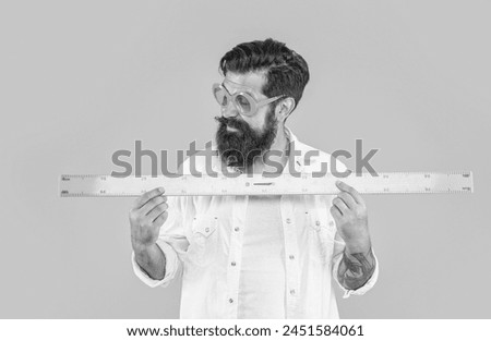cheerful man hold geometry ruler in studio. man hold geometry ruler on background