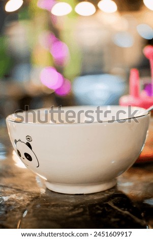 a white bowl with a picture of a panda on the table for eating
