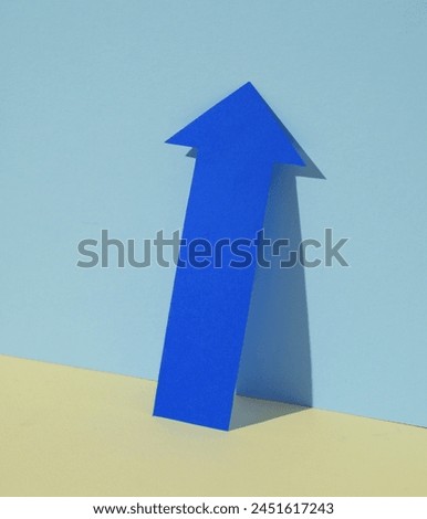 Blue up arrow on pastel background. Creative layout