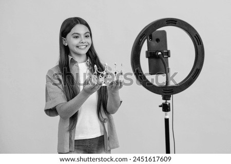 glad teen girl influencer with crown isolated on yellow. teen girl influencer with crown in studio. teen girl influencer with crown on background. teen girl influencer with crown.