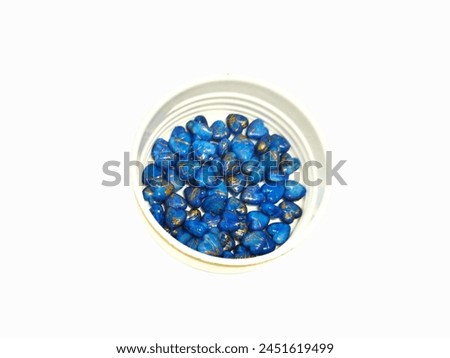 Small heart shape beads for crafting in a bowl, isolated on white background