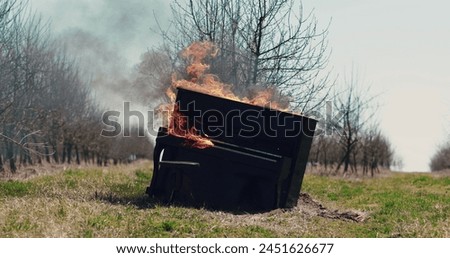 The piano burns with a bright flame. Piano on fire, slow motion. Fire from the piano. Artistic conception of the scene.