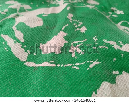 close up image of a white map of Indonesia on a green cloth