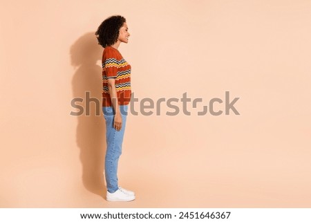 Side profile full size photo of optimistic girl dressed ornament t-shirt look at offer empty space isolated on pastel color background
