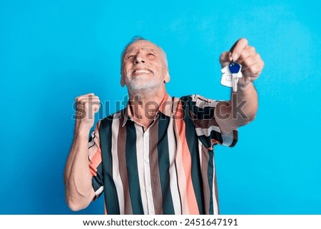 Photo of happy cheerful glad retired man wear striped trendy clothes buy new flat isolated on blue color background