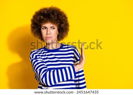 Portrait of pretty young woman arm stop empty space wear striped shirt isolated on yellow color background