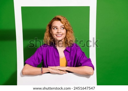 Photo of lovely young lady lean on instant photo frame look empty space dressed stylish violet clothes isolated on green color background