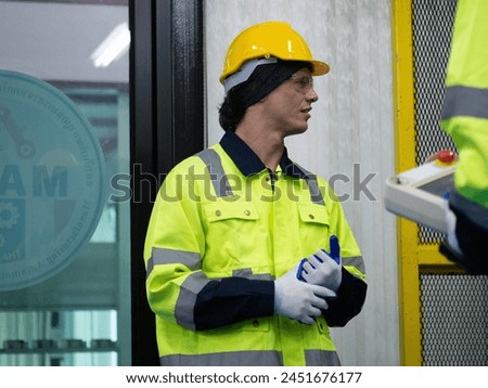 Labor employ man male young adult yellow hardhat helmet safety uniform factory engineer construction facility professional manufacturing technician work production headwear development foreman project Royalty-Free Stock Photo #2451676177