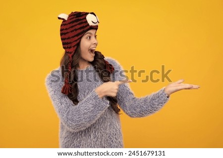 Amazed teenager. Winter hat. Cold season concept. Winter fashion accessory for children. Teen girl wearing warm knitted hat. Excited teen girl.