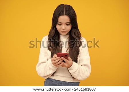Child girl 12, 13, 14 years old with smart phone. Hipster teen girl types text message on cellphone, enjoys mobile app. Kid hold smartphone texting in online social media. Internet addiction. Royalty-Free Stock Photo #2451681809