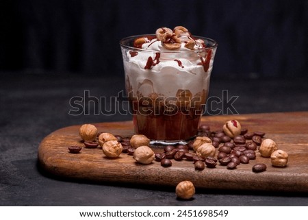 Glasses of tasty coffee mousse dessert semifreddo - half-frozen ice cream with hazelnuts on black and  brown background with whipped cream  in small glasses Royalty-Free Stock Photo #2451698549