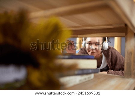 Apartment, duster and woman with headphones, cleaning furniture, listening to music and remove dirt. Person, housekeeping and girl with headset, maid and routine with podcast and radio with sound