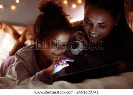 Woman, girl kid and tablet in bed, storytelling or watch cartoon at bed time with bonding and love at family home. Mother, daughter and together in bedroom at night with ebook, games or movie