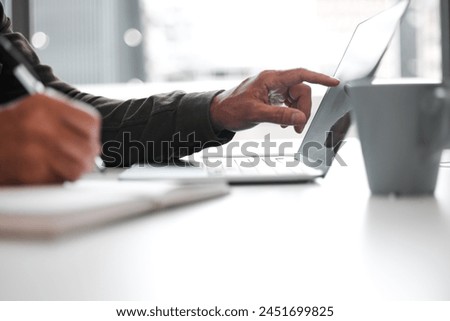 Hands, laptop and writing with business person at desk in office for information, planning or research. Diary, journal or notebook for agenda, calendar or schedule with employee in workplace closeup Royalty-Free Stock Photo #2451699825