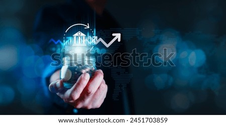 A person is holding a jar of coins and the jar is surrounded by a bank icon and a graph showing an upward trend. Business, investment, stock and marketing Concept