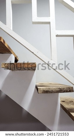Picture of wooden textured stair of the house with white rail.