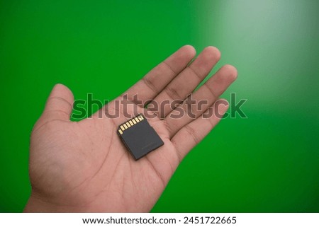 memory card placed in the palm of the hand, with a green screen background, April 19 2024, Yogyakarta Indonesia.