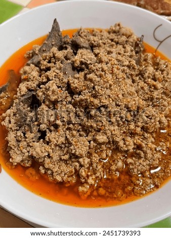 a photography of a bowl of soup with meat and sauce.