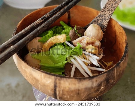 a photography of a bowl of food with chopsticks and a bowl of noodles.