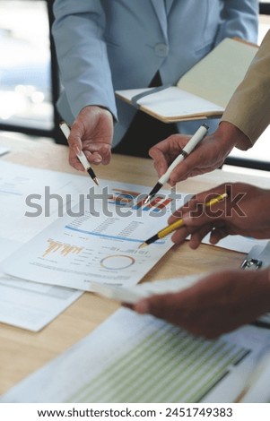 Group of business people meeting, discussion, brainstorming, pointing at graphs and charts to analyze market data, calculating balance sheets, accounts, net profits to plan company sales strategies.