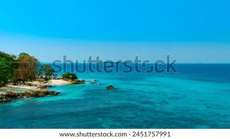 Nature of the beach and sea Summer with sunshine, sandy beaches, clear blue waters sparkling against the blue sky. On an island that has an abundance of forests Background for summer vacation concept