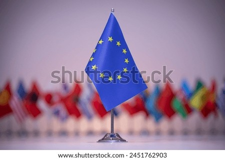 a small flag of the european union is sitting in front of a row of other flags