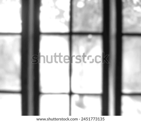 Photo of object framing blurry black and white window glass out of focus, glass out of focus on photo in glass frame at home