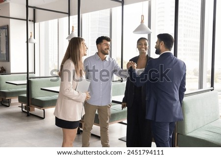 Positive diverse team of managers giving friends handshake, enjoying team success, office friendship, teamwork, synergy, shaking hands with gratitude, approbation