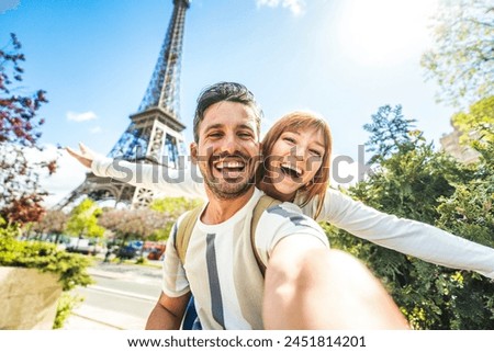 Happy couple of tourists taking selfie picture in front of Eiffel Tower in Paris, France - Travel and summer vacation life style concept