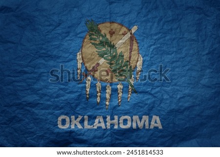 colorful big national flag of oklahoma state on a grunge old paper texture background