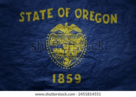 colorful big national flag of oregon state on a grunge old paper texture background