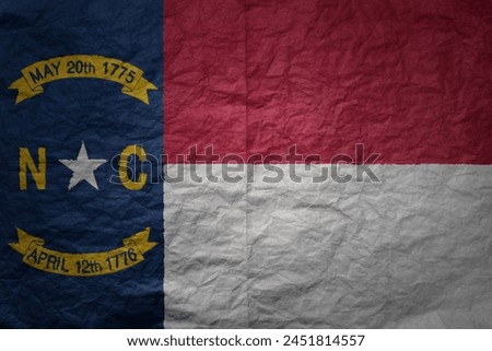 colorful big national flag of north carolina state on a grunge old paper texture background