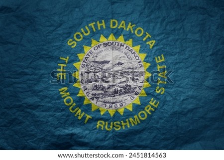 colorful big national flag of south dakota state on a grunge old paper texture background