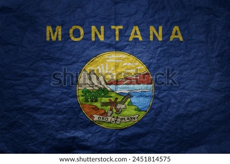 colorful big national flag of montana state on a grunge old paper texture background
