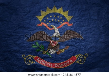 colorful big national flag of north dakota state on a grunge old paper texture background