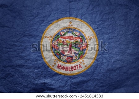 colorful big national flag of minnesota state on a grunge old paper texture background