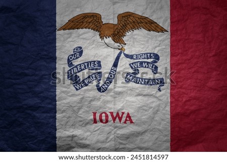 colorful big national flag of iowa state on a grunge old paper texture background